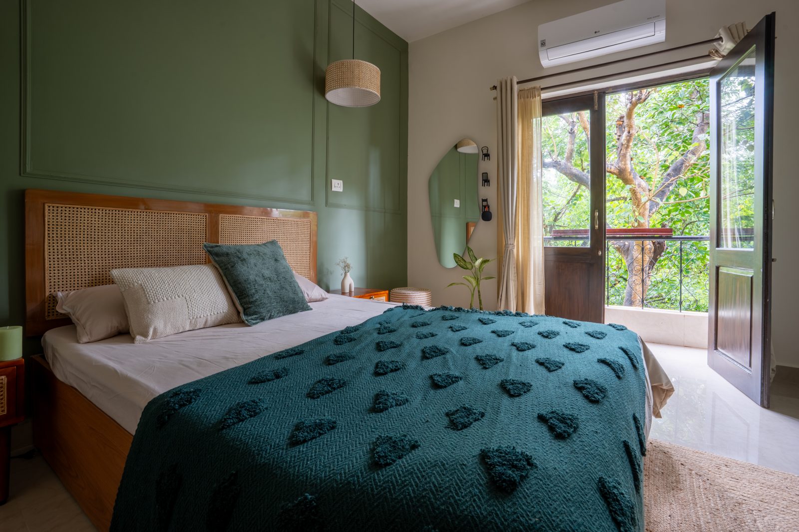 Olive green bedroom with rattan headboard and garden view at The Olive Room